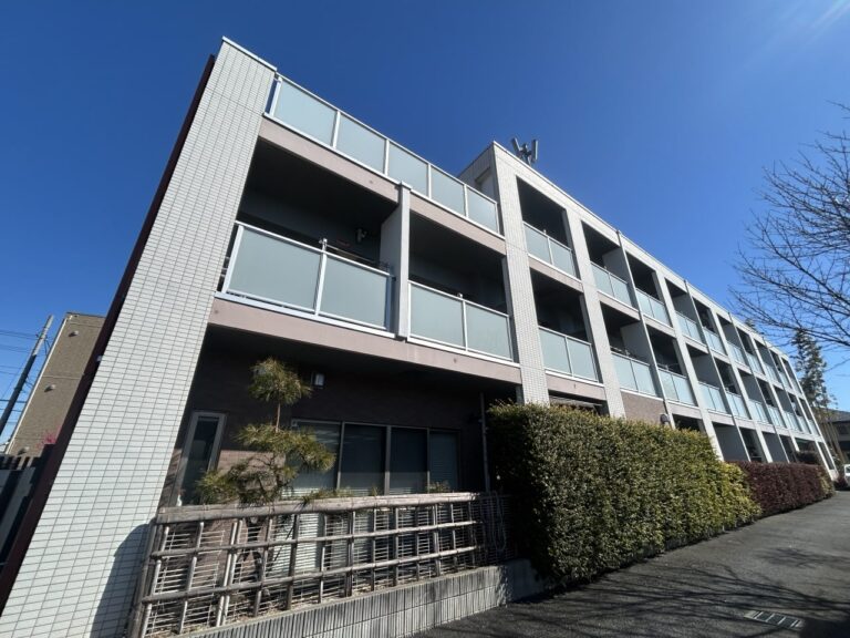白タイル張りの介護施設建物外観。複数階建てで大きな窓が特徴